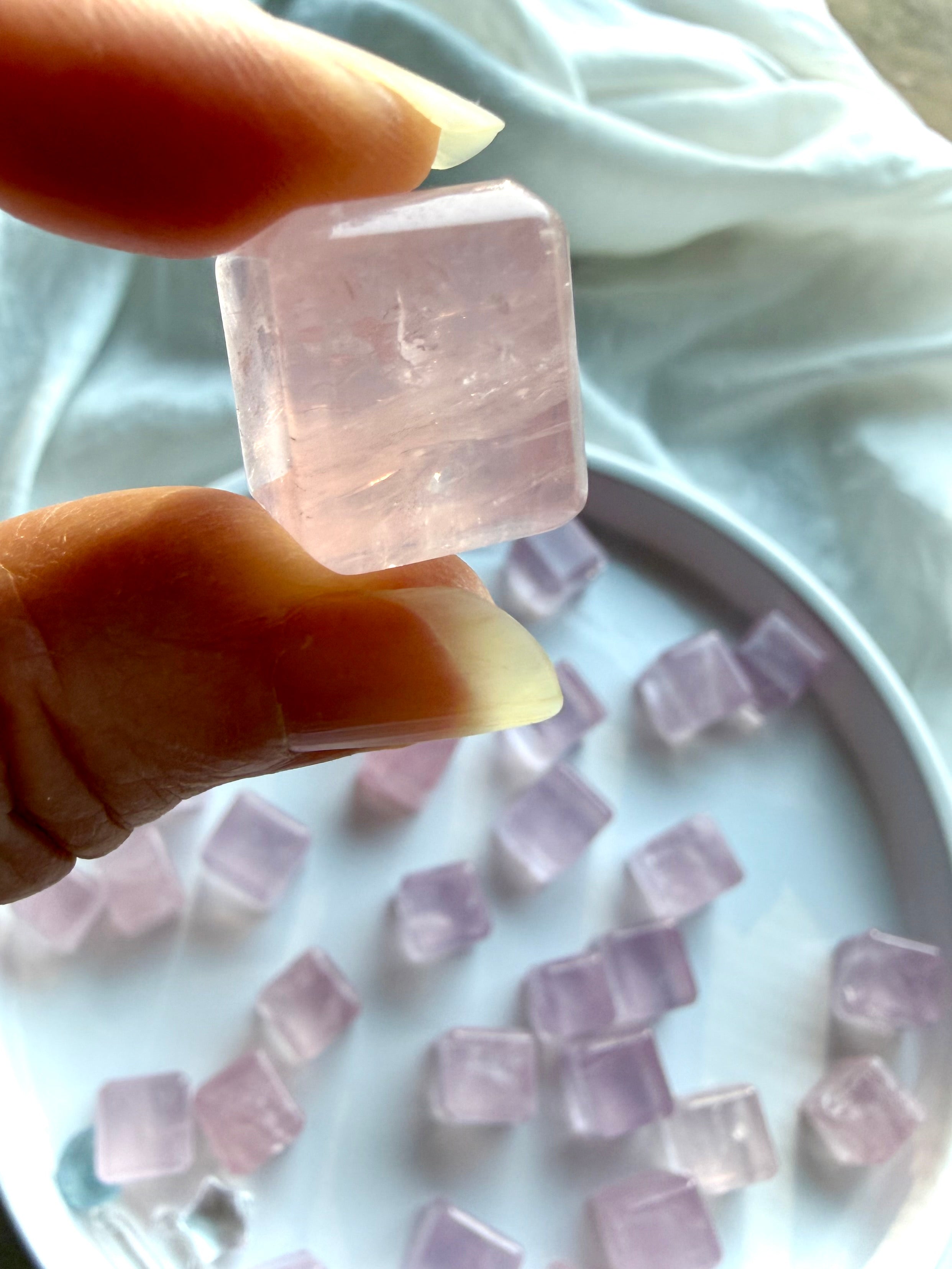 Close-up of a polished rose quartz mini cube showing natural crystal texture, beveled edges, and gentle pink glow
