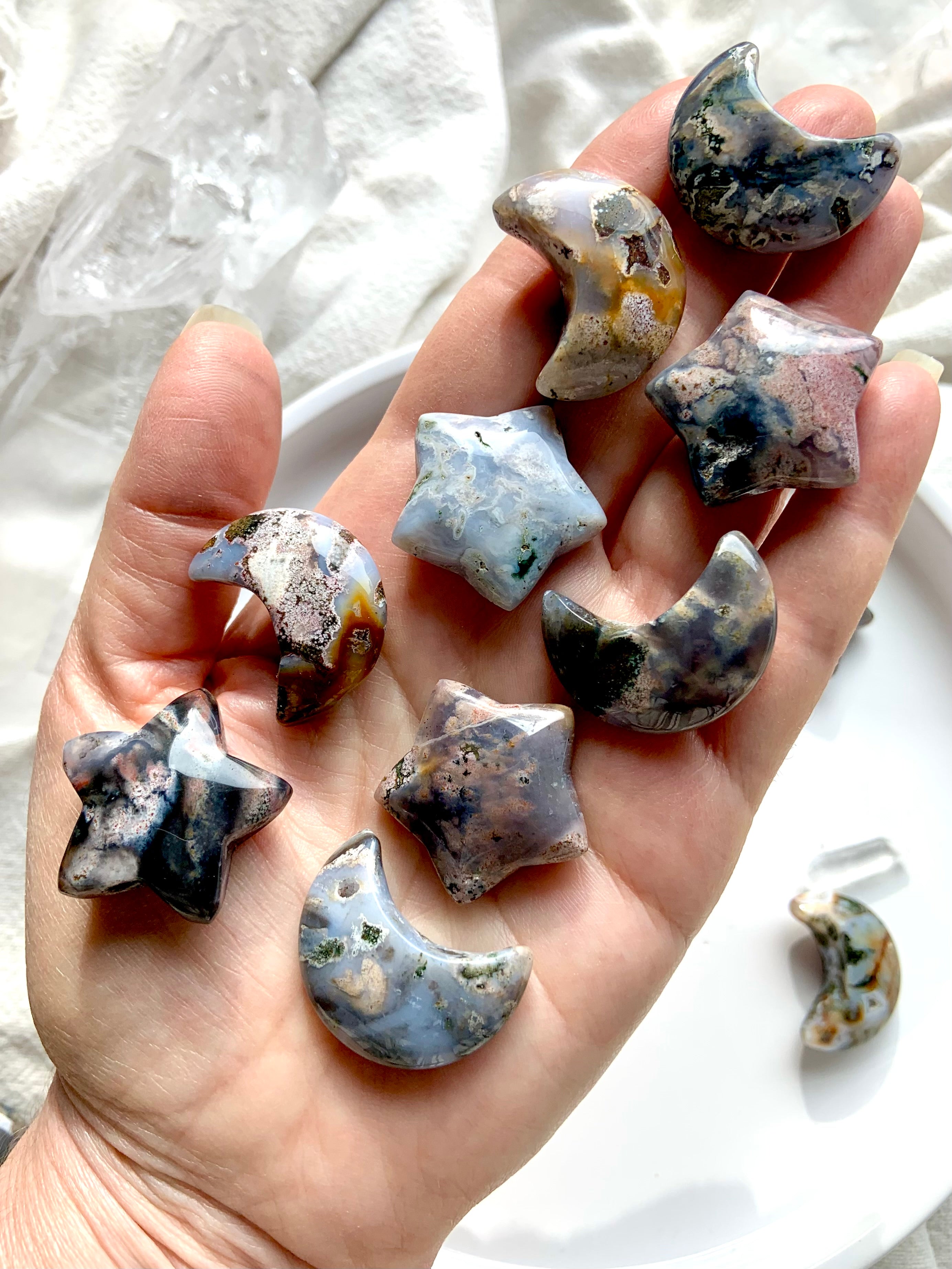 Cosmic Ocean Jasper moons and stars crystal carvings displayed on hand for size reference, grounding and heart chakra healing crystals