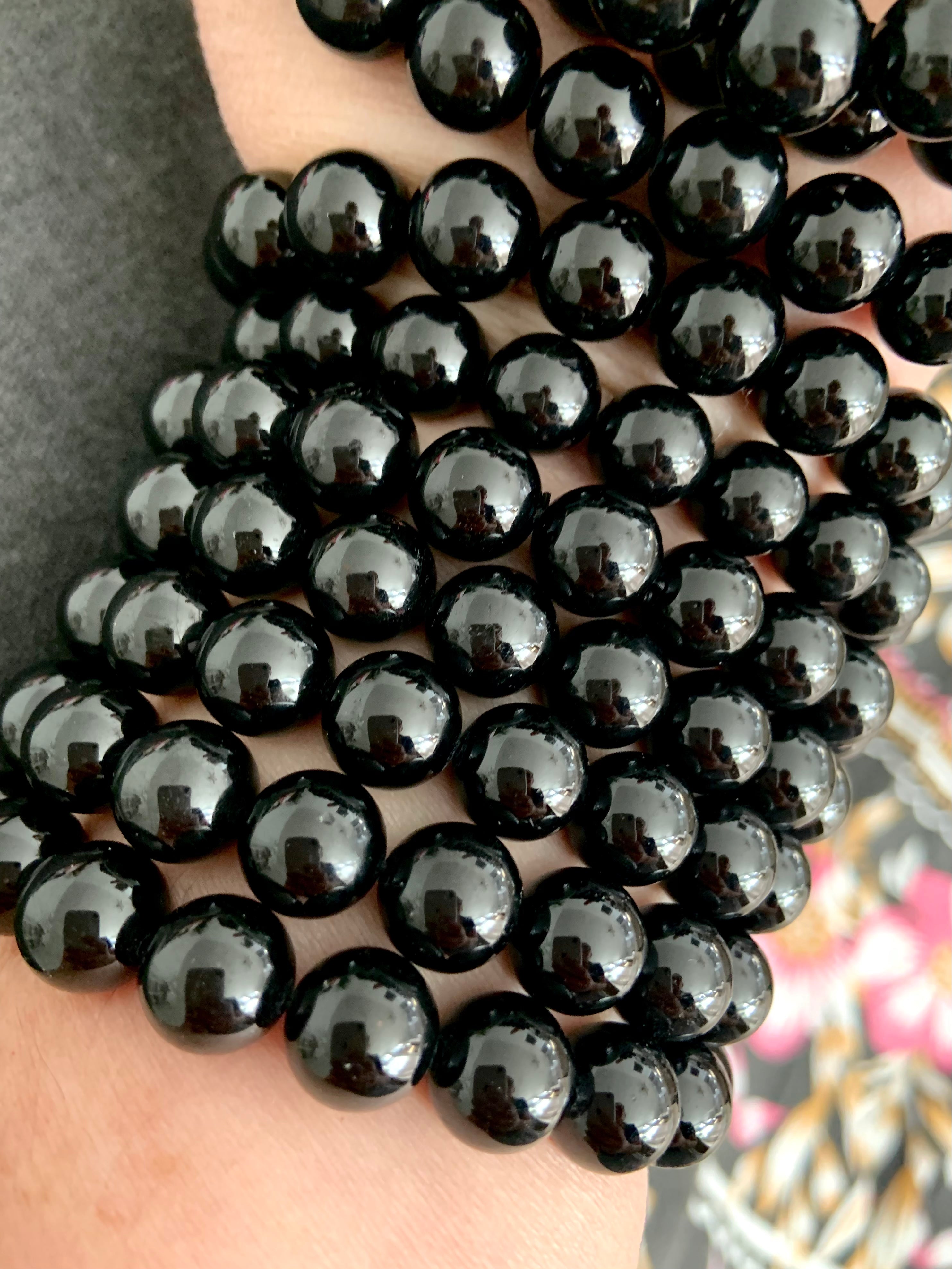 Closeup of a high quality Black Tourmaline bracelet stack with glossy polished beads for energetic protection and grounding