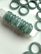 Rounded Blue Water jade rings arranged on white surface, natural Guatemalan jadeite bands