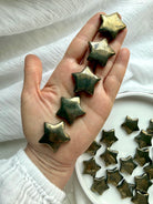 Pyrite stars held in hand showing natural golden metallic sheen and polished crystal finish
