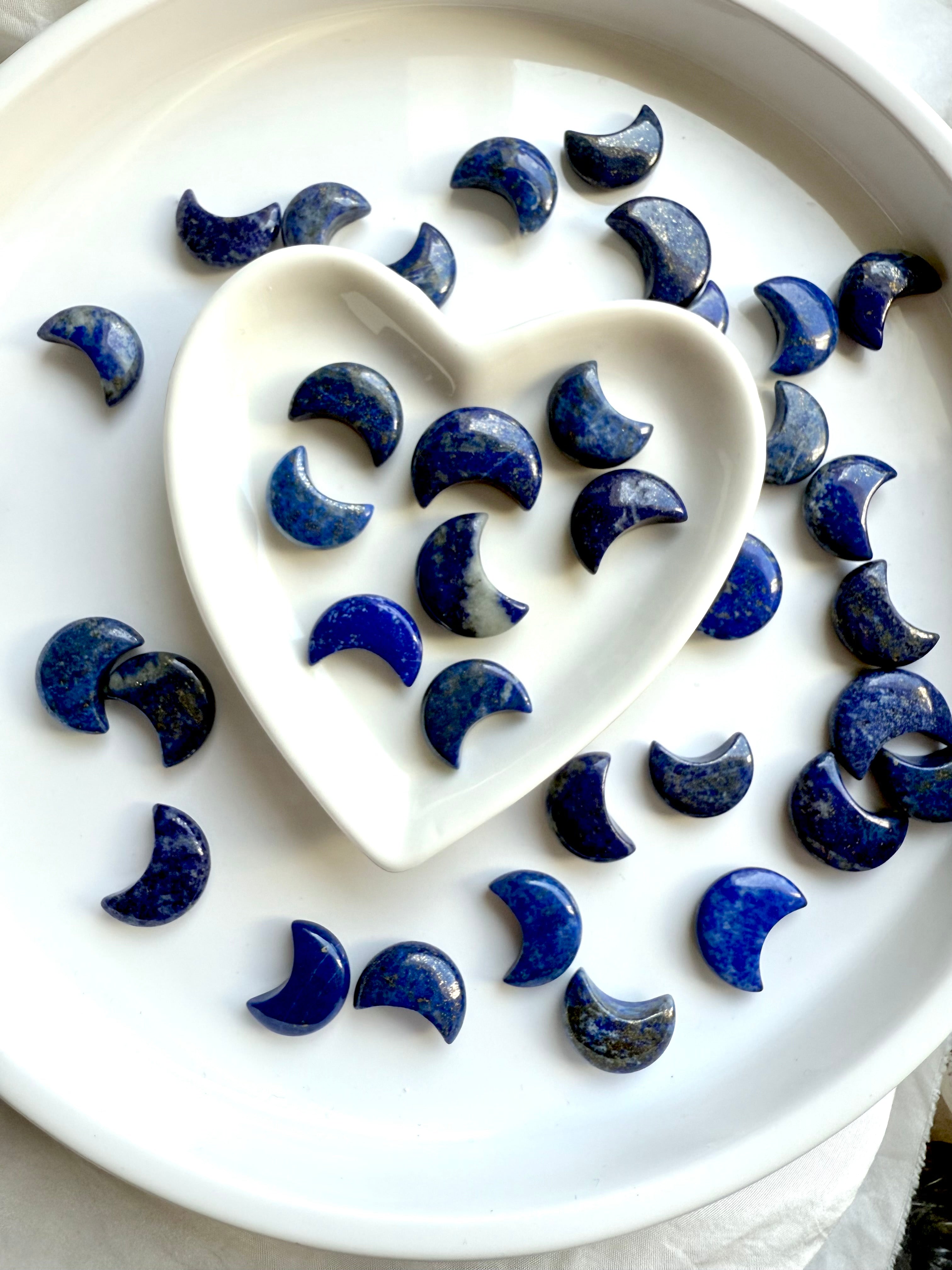 Lapis Lazuli mini moon carving – sacred crystal for wisdom and truth shown in a white heart bowl