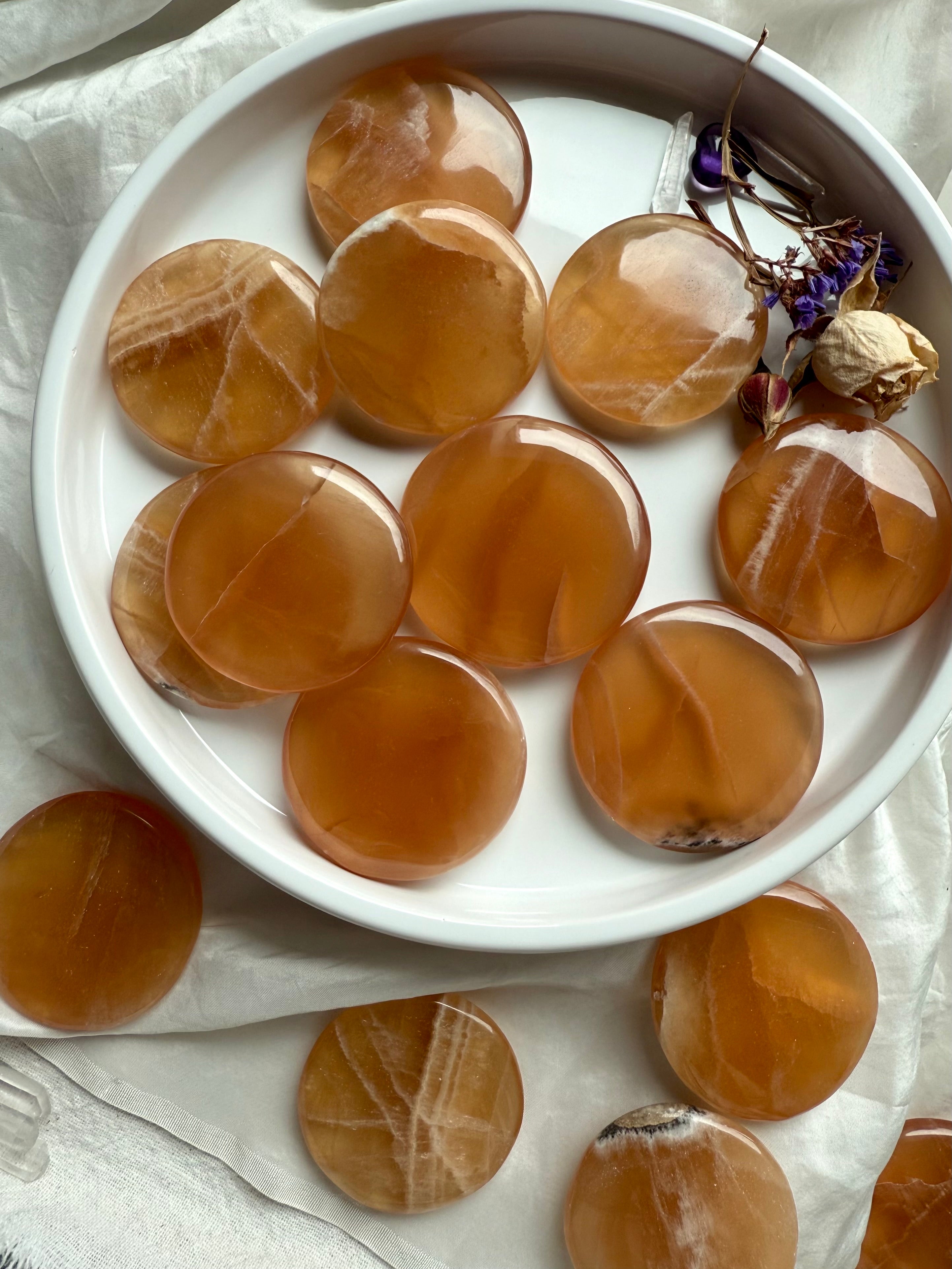 Honey calcite palm stones photographed in soft daylight, emphasizing its warm color and subtle internal textures for chakra healing.