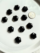 Small faceted Obsidian crystal with quarter for scale