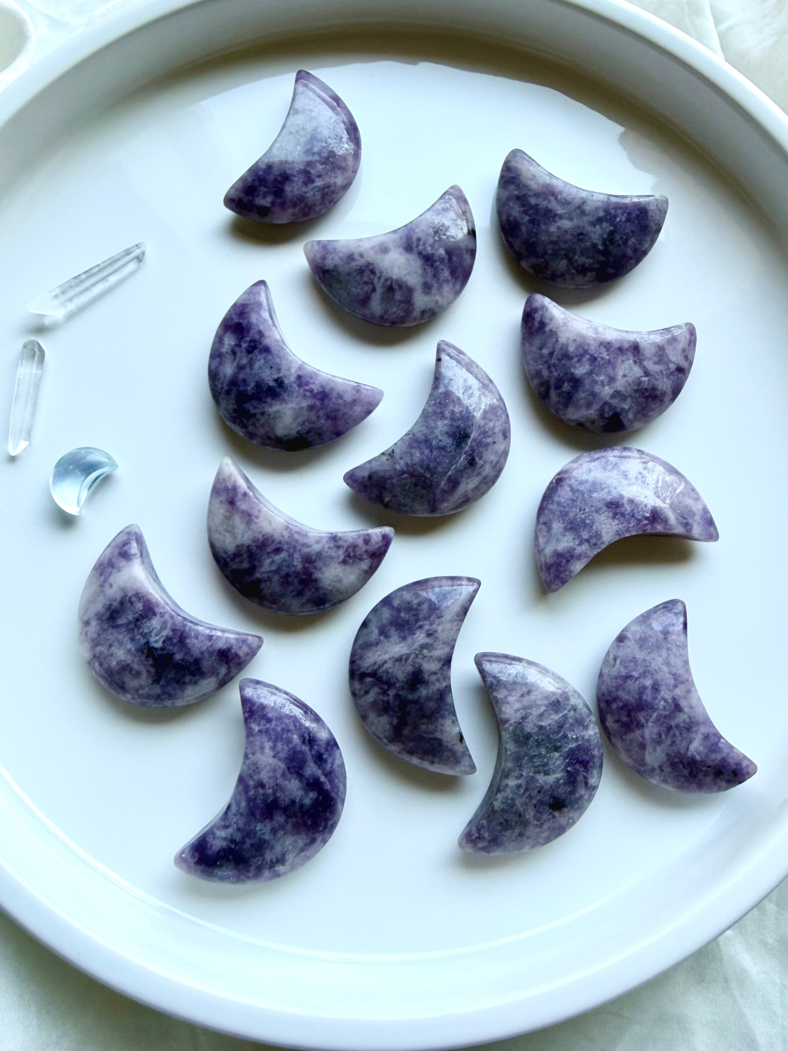 Celestial Lepidolite crystal carvings featuring polished crescent moons and stars in naturally varied shades of purple