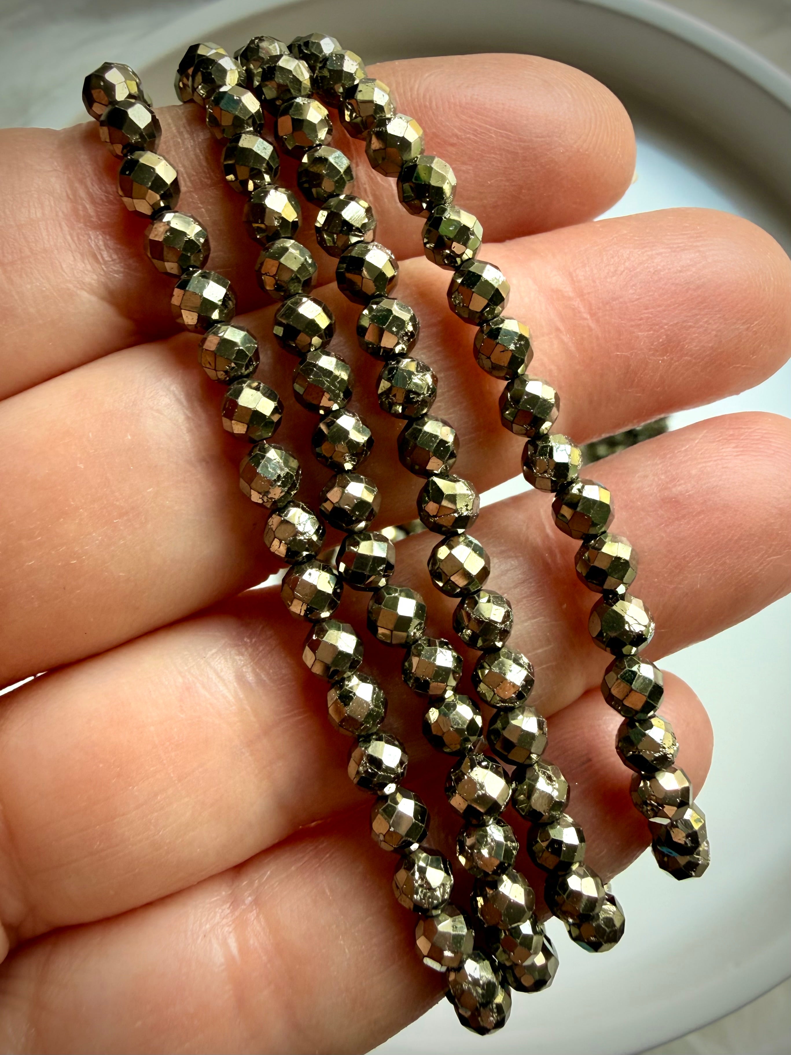 pyrite bead bracelets layered on wrist showing faceted texture and solar plexus energy jewelry