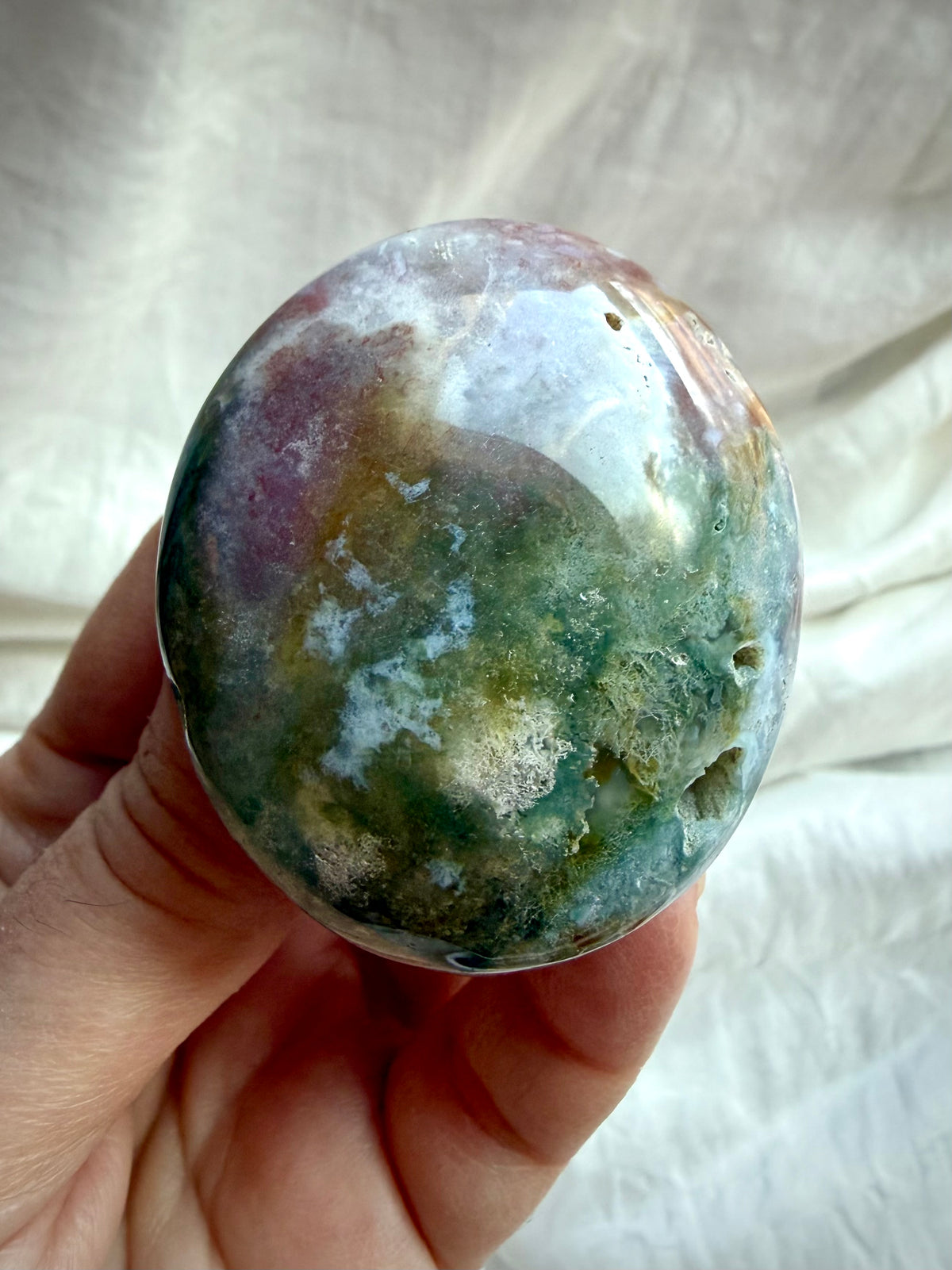 Ocean Jasper palm stone with contrasting cream, pink, and dark green patterns, polished smooth with natural mineral inclusions