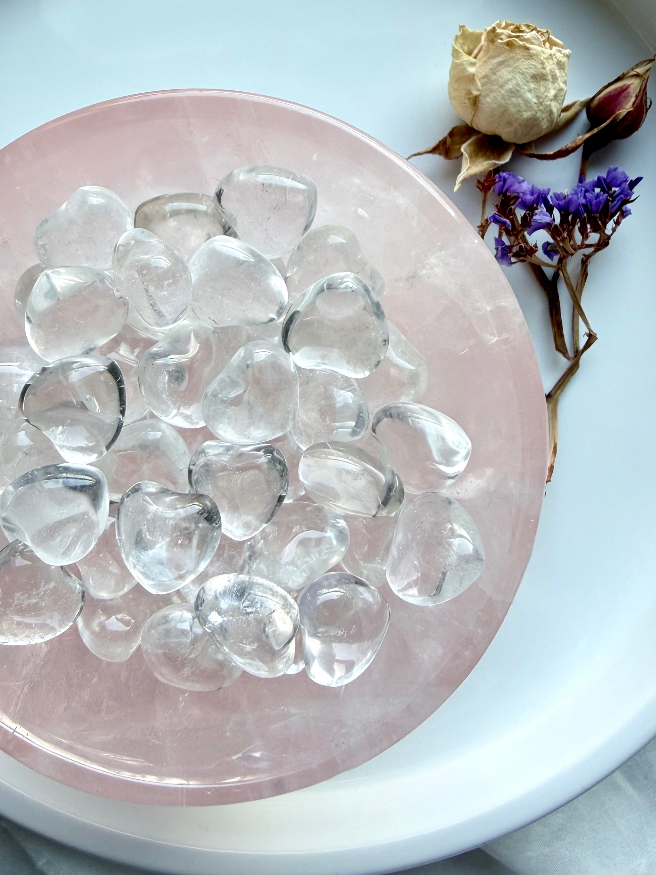 Mini Clear Quartz crystal hearts displayed in a rose quartz bowl with luminous transparent quartz
