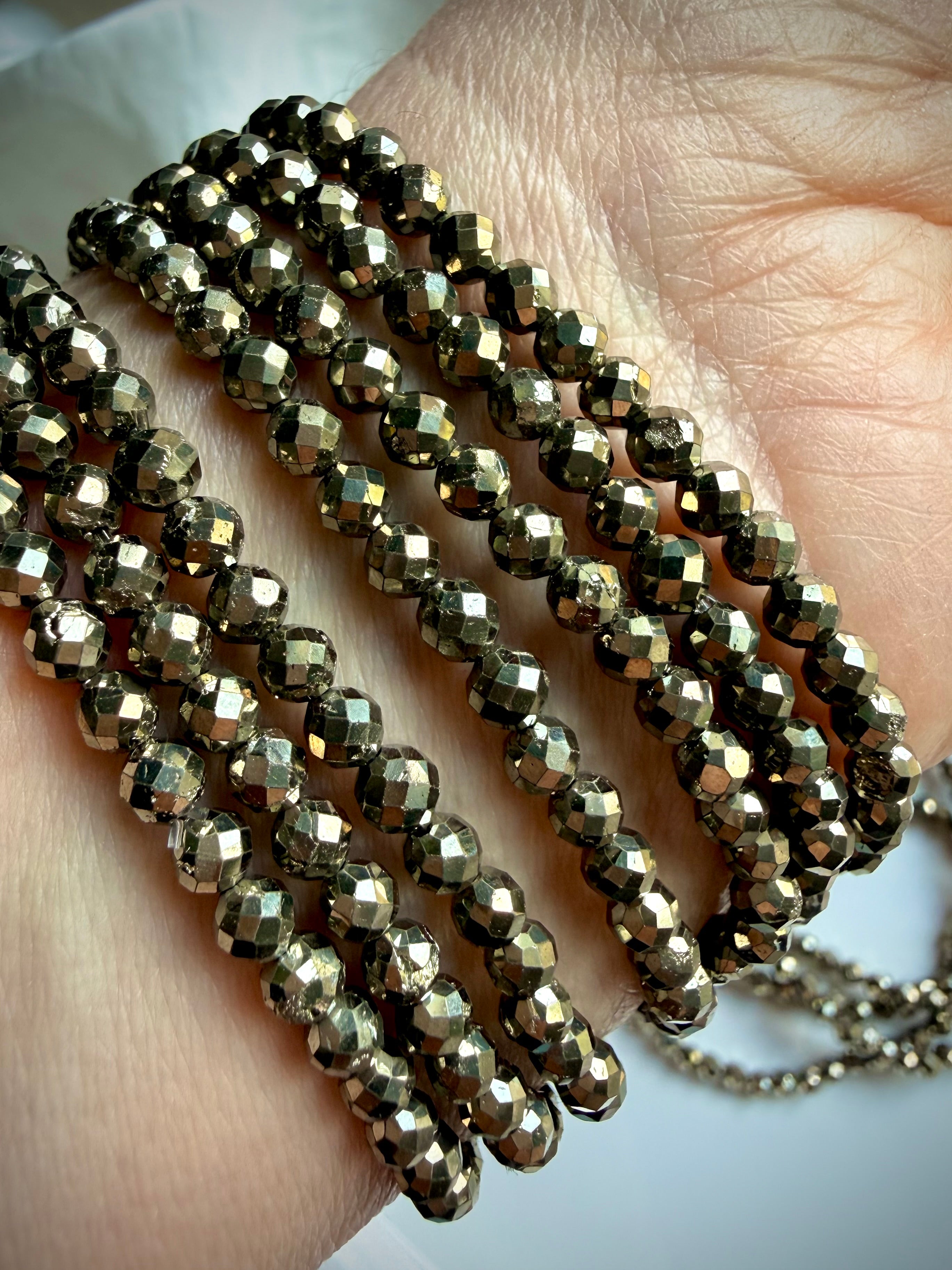 faceted pyrite bracelet stacked on wrist with high shine metallic beads for confidence protection and abundance