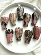 choose your own Rhodonite angel carvings numbered 1–9 showing back view with natural matrix patterns