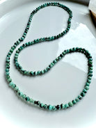 Turquoise necklace variation displayed in an elegant loop with smooth, natural gemstone beads in blue-green tones