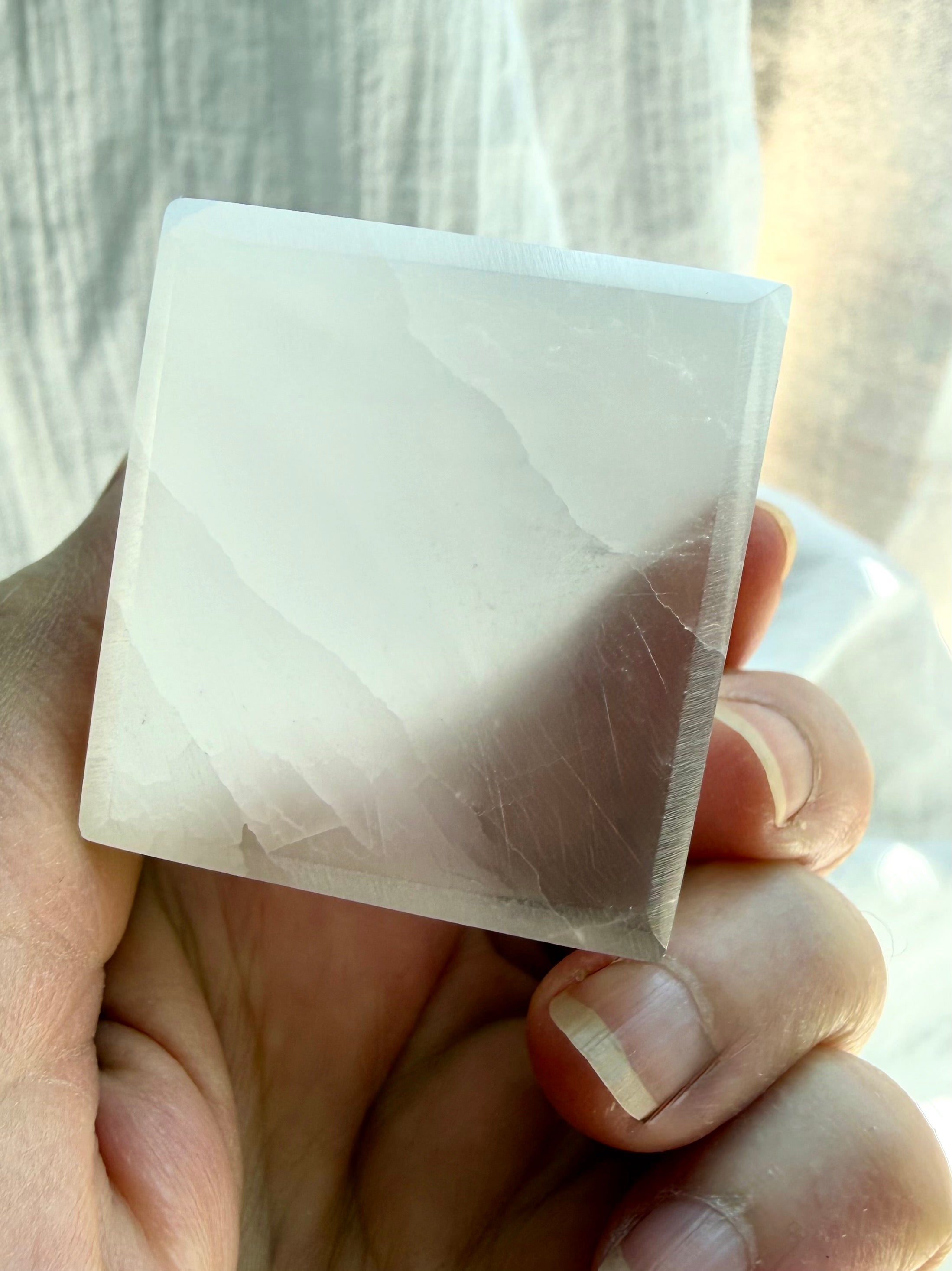 Close-up of Selenite cube with silky white striations and translucent satin spar crystal structure