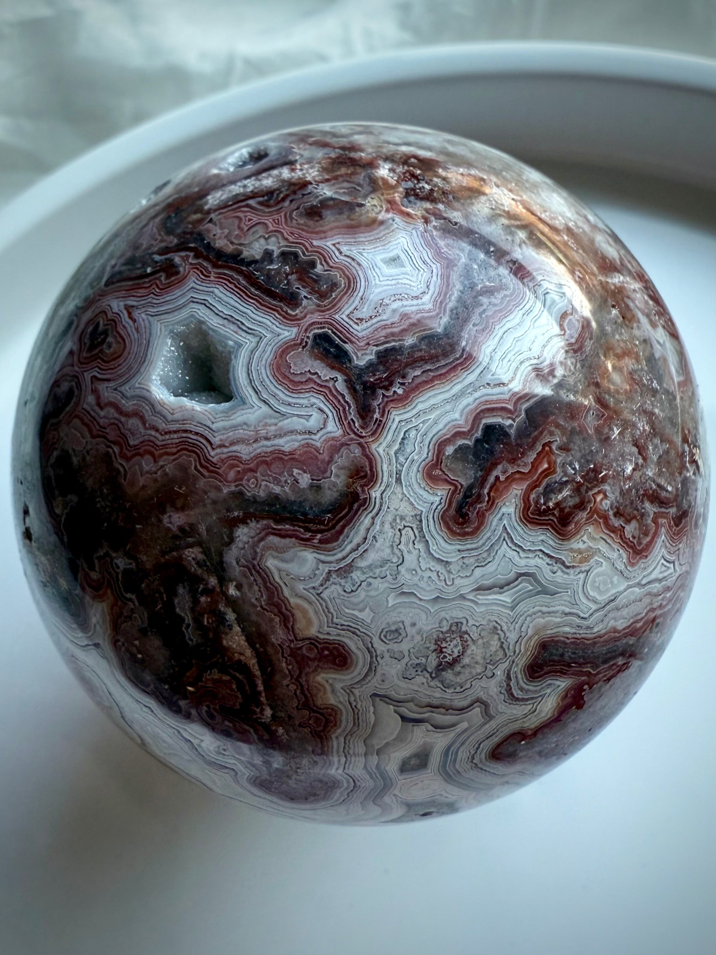 Crazy Lace Agate sphere rotated to display natural druzy pocket and joyful, protective Root Chakra vibes
