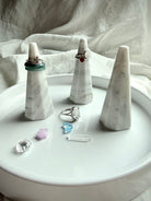 White and gray marble ring holder stand for rings with faceted sculptural design on modern jewelry display