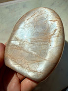 Large Peach Moonstone freeform with reflective silver flash and natural feldspar character visible in angled lighting