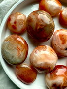 Carnelian palm stones with fiery banding + druzy details — energizing sacral chakra crystals for joy + creativity