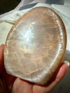 Peach Moonstone crystal showing silvery glow, golden Sunstone sparkle and natural rainbow reflections in angled light