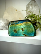 Polished Labradorite freeform with blue green flash displayed in home decor with crystals