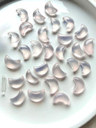 Mini Rose Quartz moons arranged on a white dish, small crystal carvings for love and Heart Chakra healing