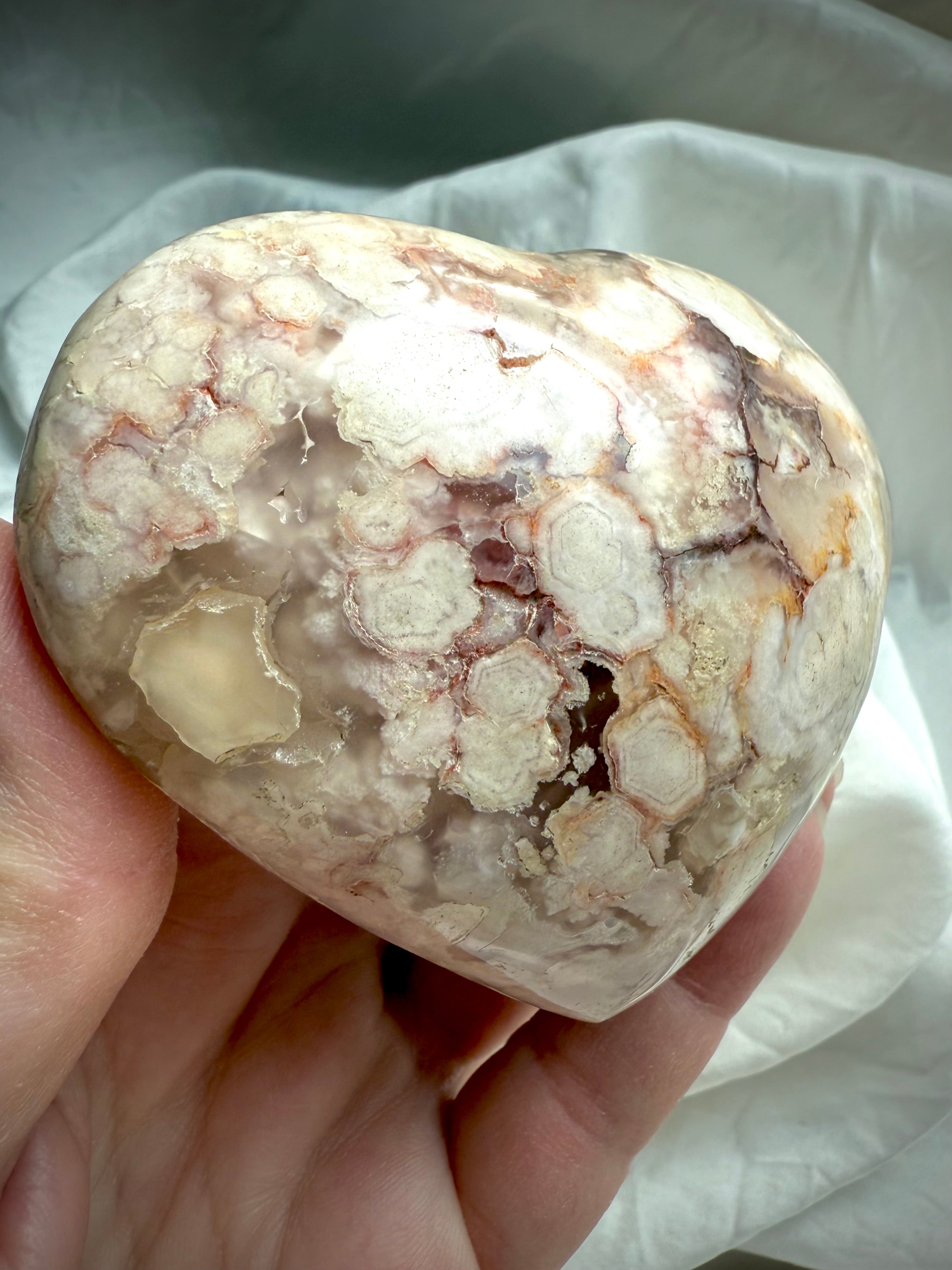 Detailed view of a Flower Agate heart with clustered blossom formations and creamy chalcedony swirls — soothing stone for self-love, renewal, and emotional resilience.