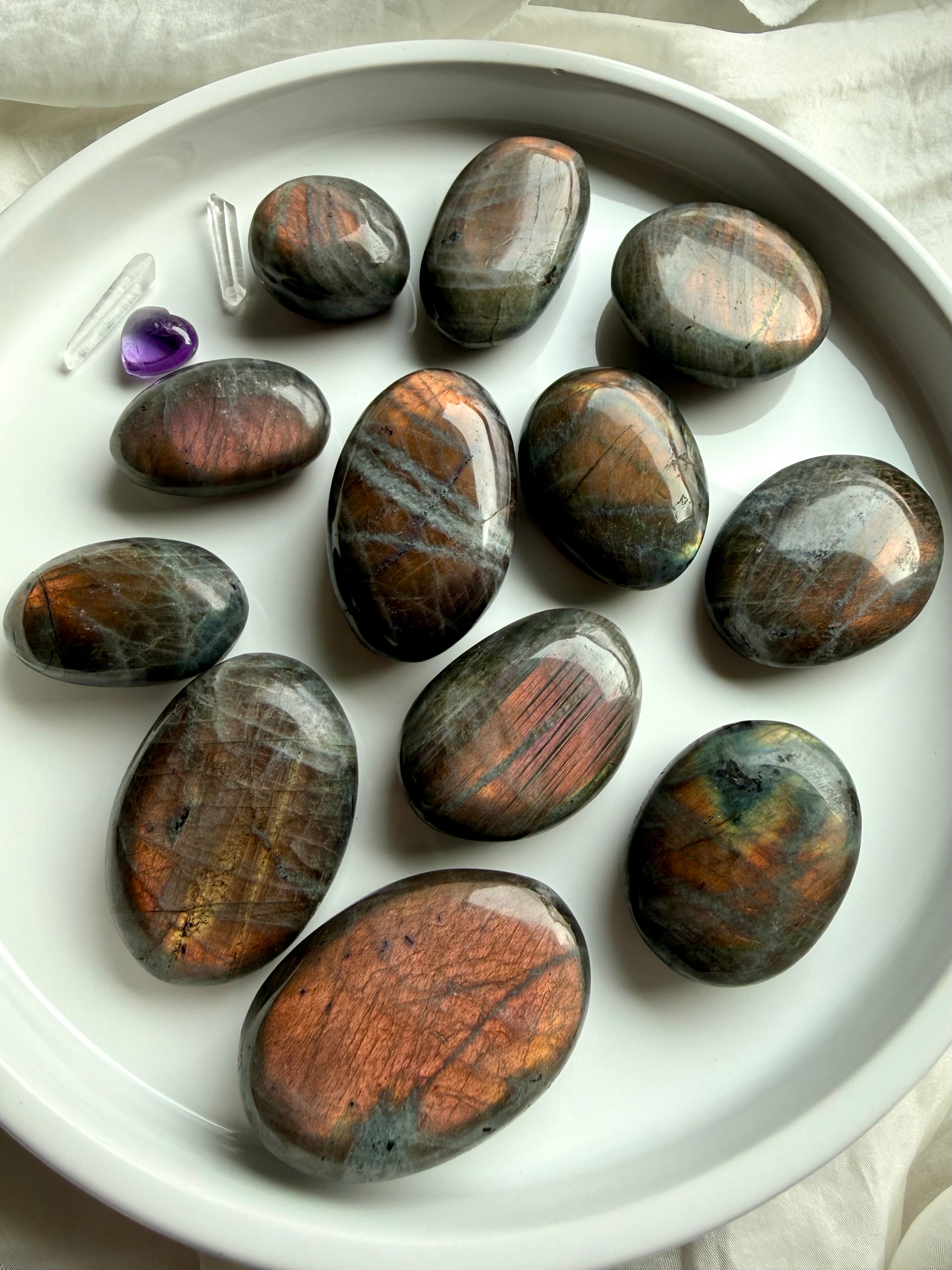 Collection of Peachy Sunset Labradorite palm stones with glowing orange and apricot labradorescence