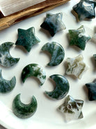Moss Agate stars and moons in various green and white patterns — grounding crystal carvings for emotional balance, Earth energy, and heart chakra harmony.