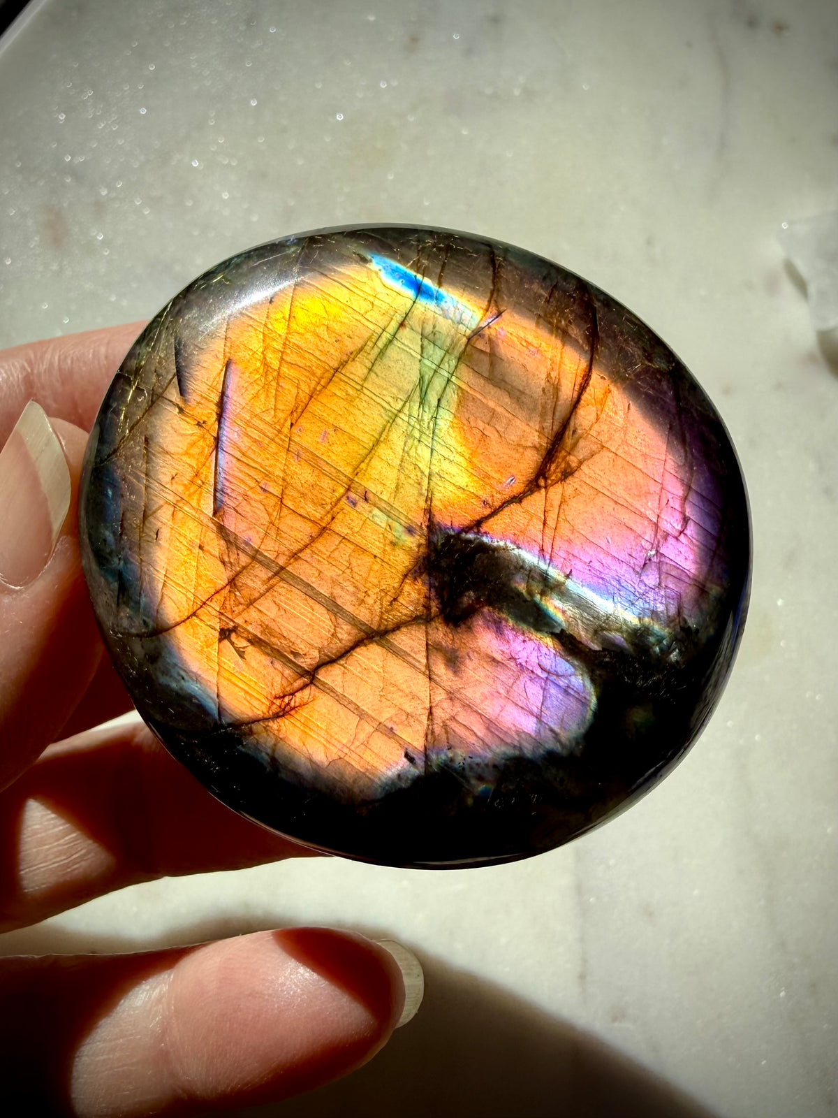 Rainbow Flash Labradorite crystal glowing with brilliant golden, green, blue and pink color for intuition and Third Eye Chakra energy