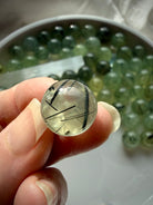 prehnite sphere close up showing fine epidote needle inclusions and internal veiling