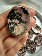 Oval Rhodonite worry stone with pink, tan and black matrix