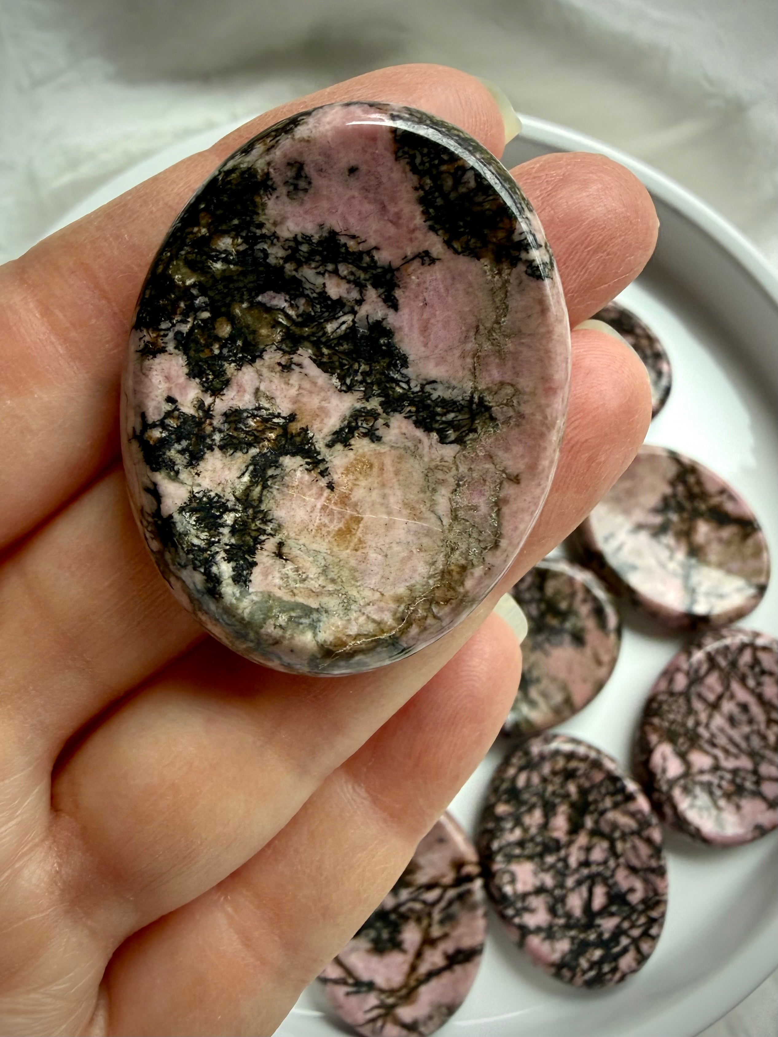 Oval Rhodonite worry stone with pink, tan and black matrix