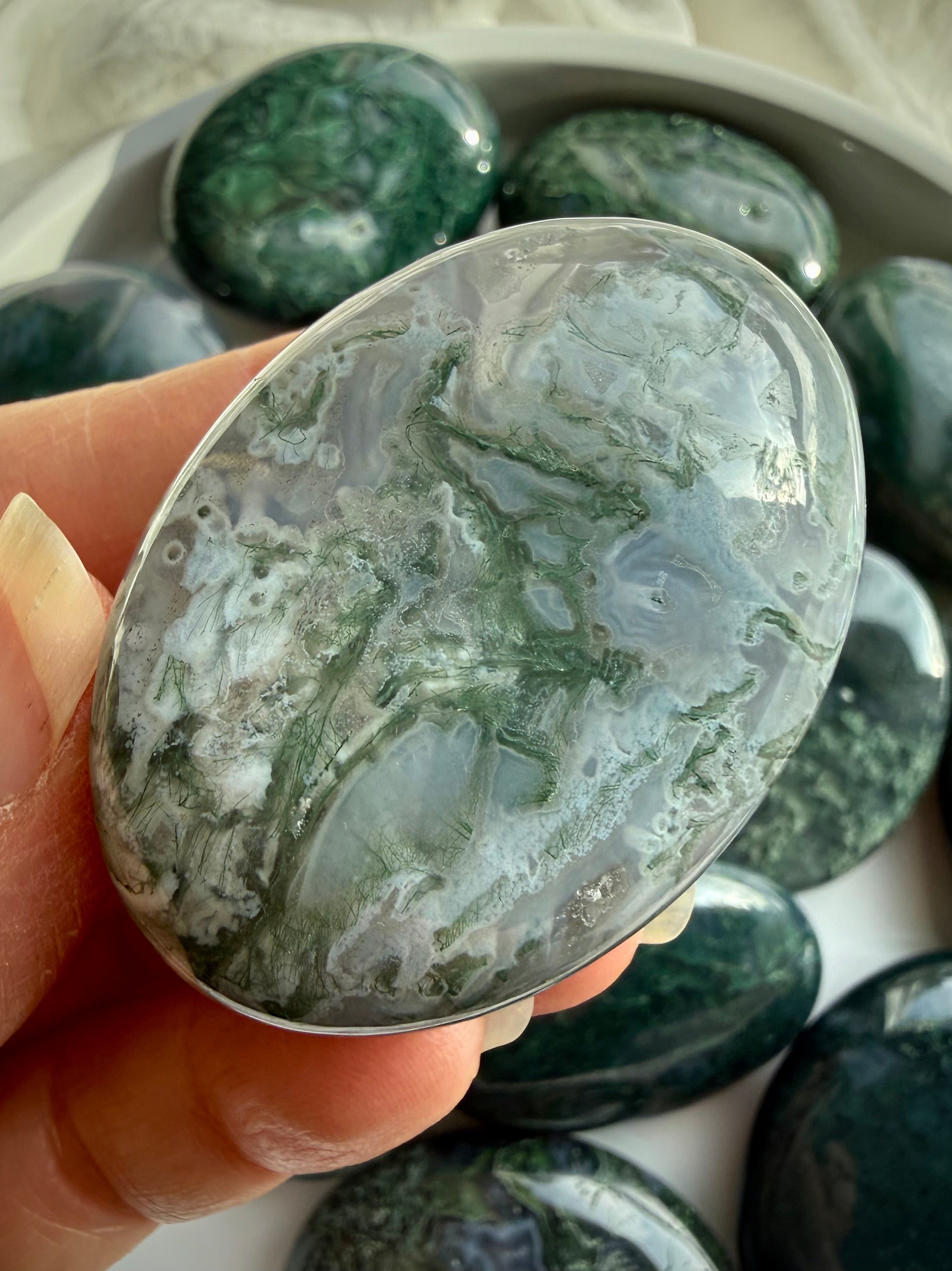 Moss agate palm stone close view showing smooth polish and comfortable palm stone shape for meditation and grounding