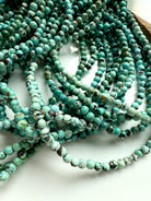 Tumbled pile of turquoise 4mm bead strands in shades of teal, mint, and aqua green