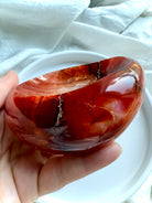 Side view of Carnelian bowl with glossy surface and natural inclusions – unique crystal offering dish