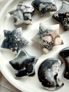 black flower agate moon and star carvings set on dish showing full assortment with natural floral plume patterns