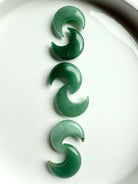 Vertical row of Green Aventurine crescent moons on white background, Heart Chakra crystals for love, luck, and emotional balance