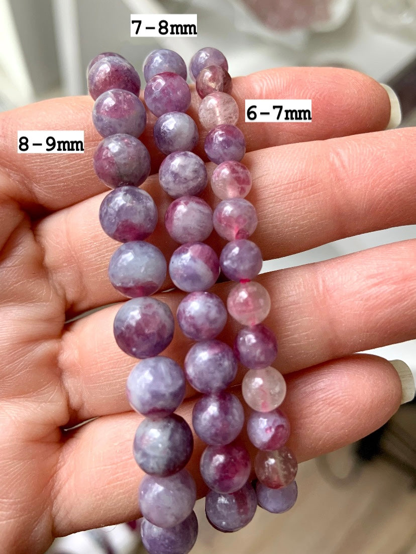 Comparison of Unicorn Stone bracelets in 6–7mm, 7–8mm, and 8–9mm bead sizes — Pink Tourmaline in Lepidolite crystal bracelets shown on hand with size markers for reference.