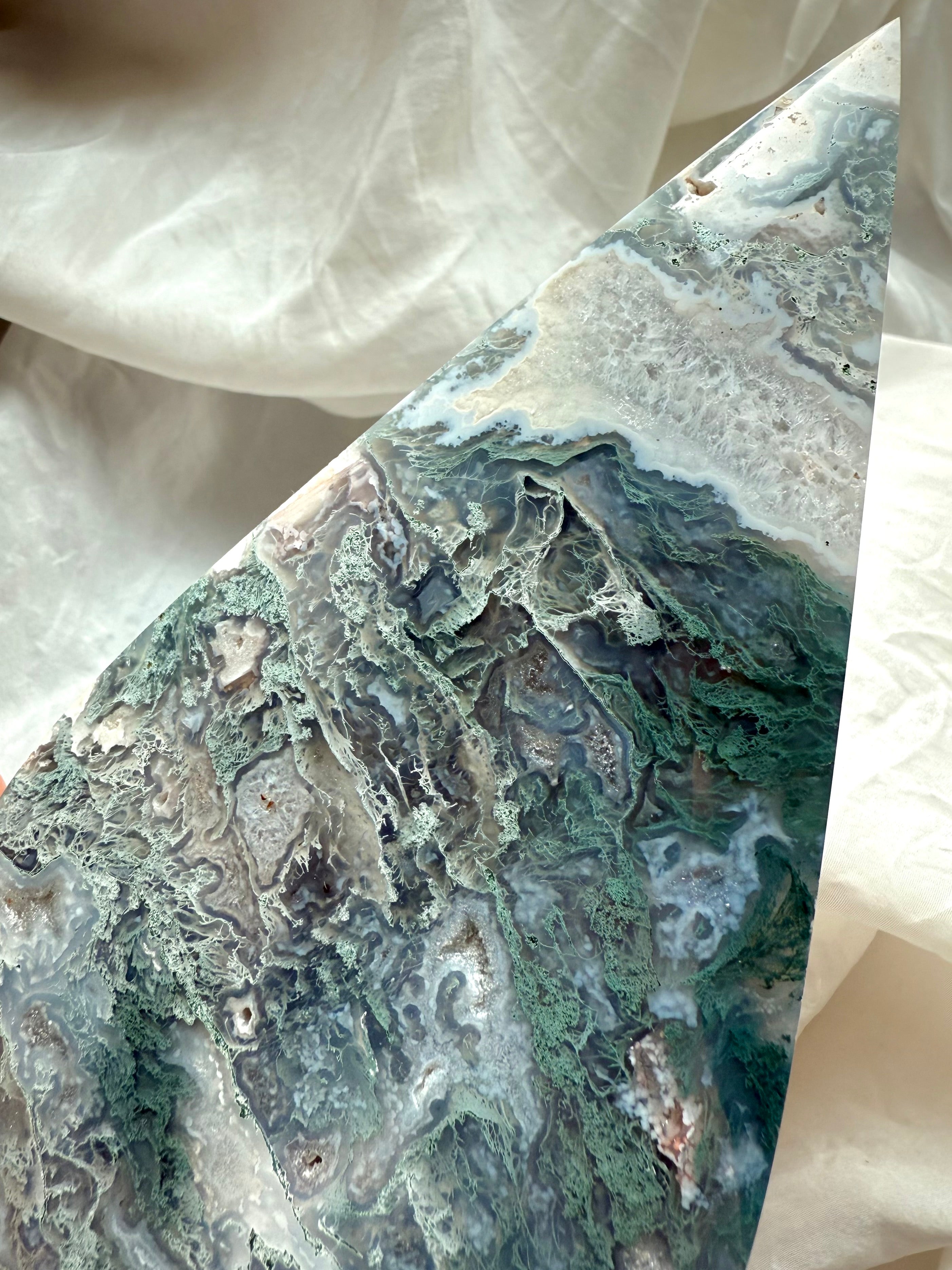 Close-up of rare moss agate crystal flame with translucent layers and quartz druzy inclusions