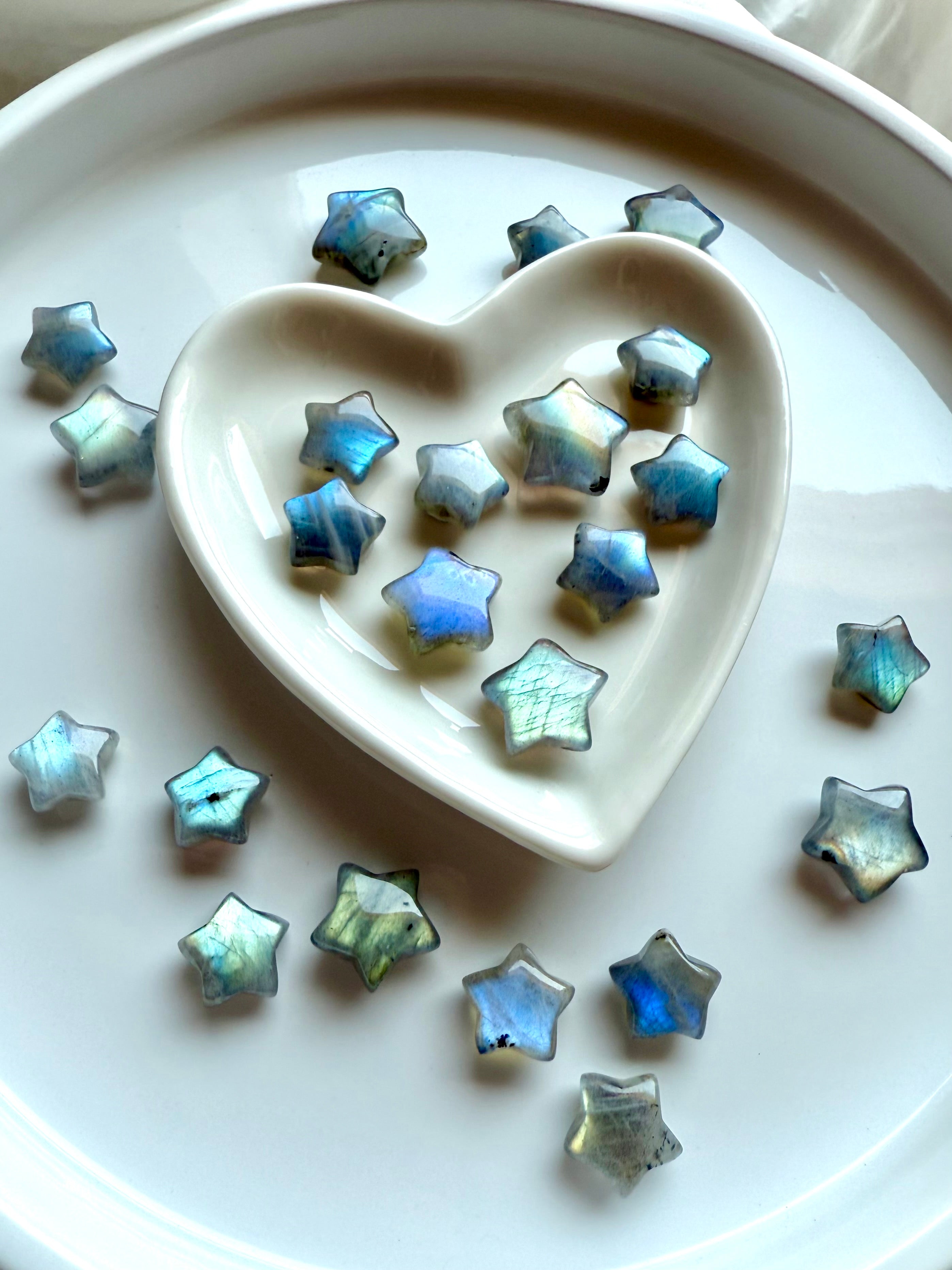 Pastel Labradorite stars in a heart bowl on a plate with more stars scattered — dreamy mini crystal stars for Third Eye chakra healing & spiritual balance.