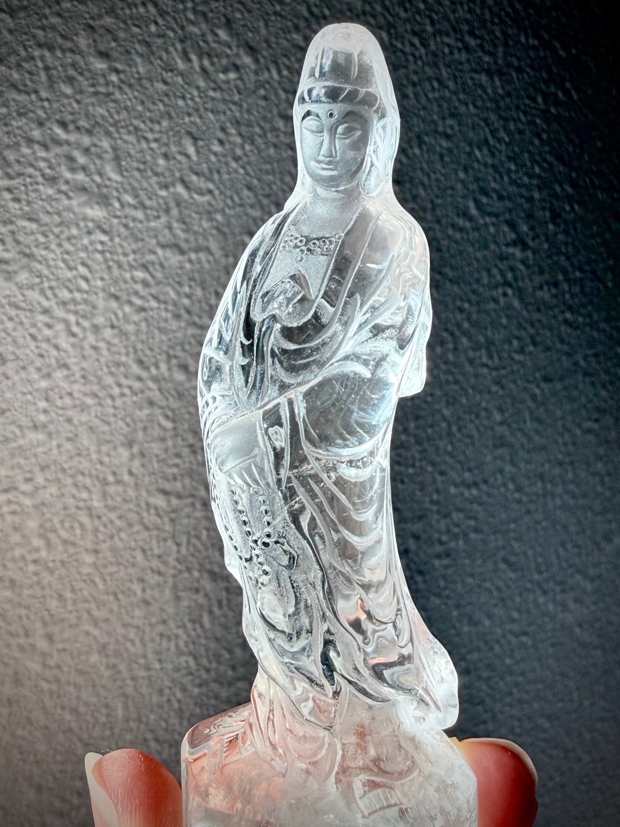 One-of-a-kind Clear Quartz Goddess of Compassion statue with intricate robes and radiant transparency