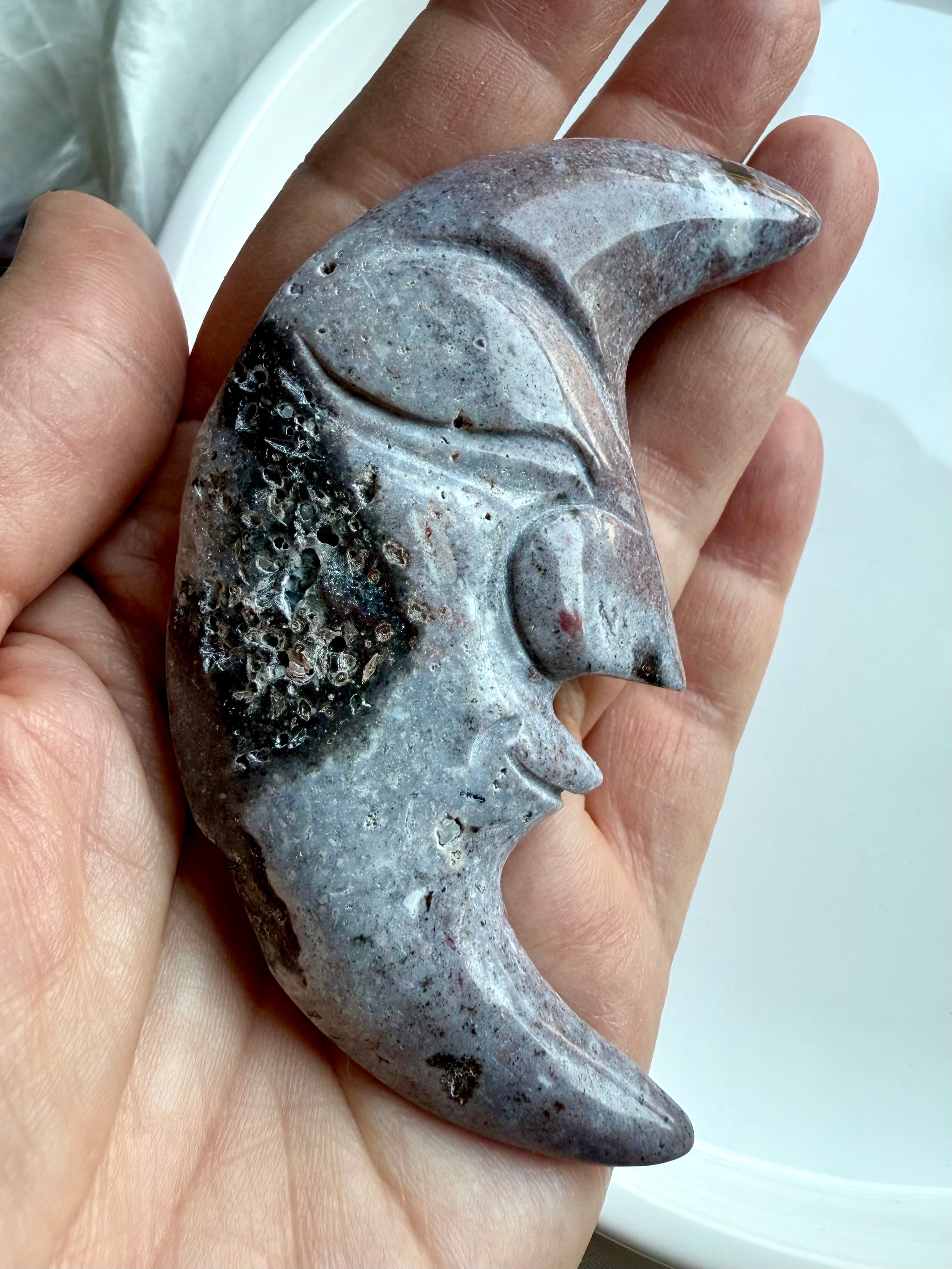 Close-up of Ocean Jasper moon face carving showing sparkling druzy pocket and stone texture.