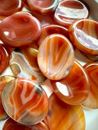 Carnelian Agate oval worry stones showing natural banding, Quartz inclusions and warm red-orange color variation