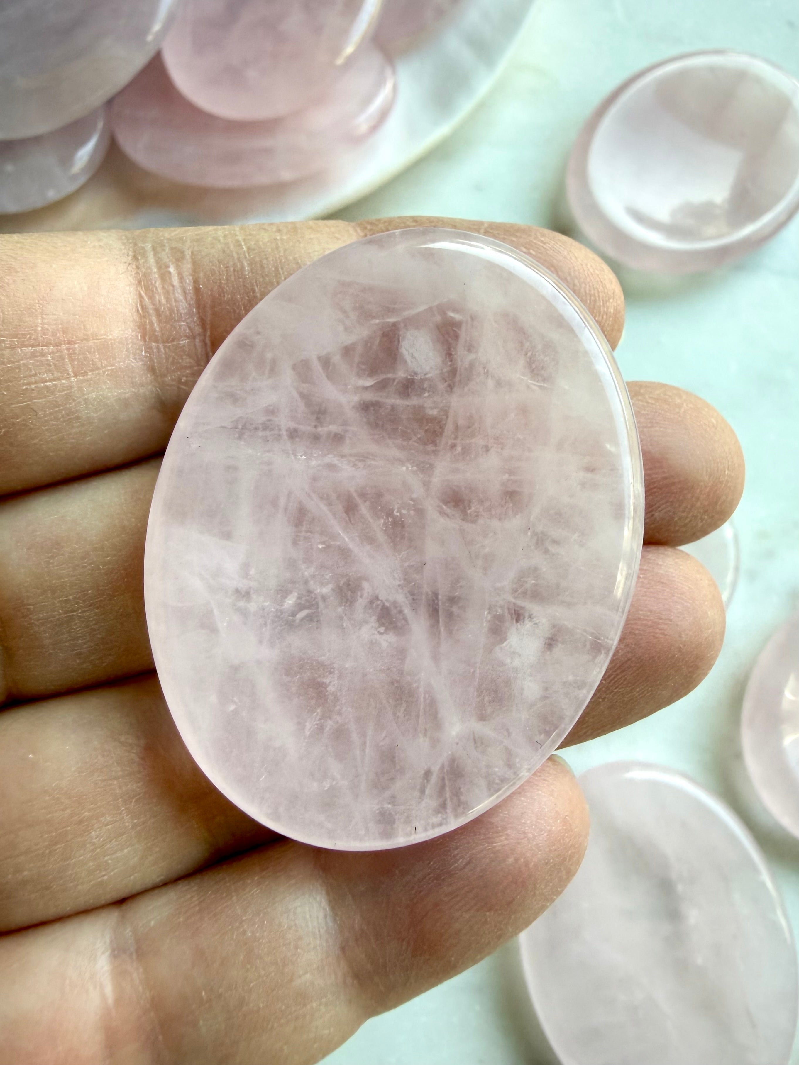 rose quartz worry stone close up showing polished surface and natural pink crystal texture