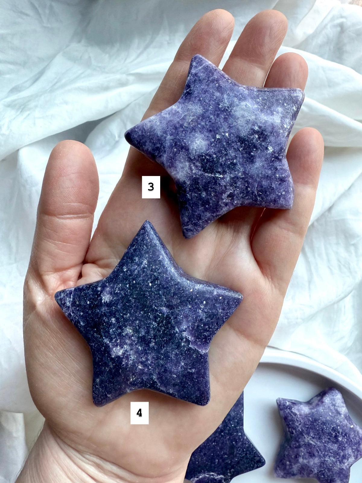 Back view of two numbered Lepidolite star carvings in deep purple with natural variations, smooth polished crystal for chakra balance.