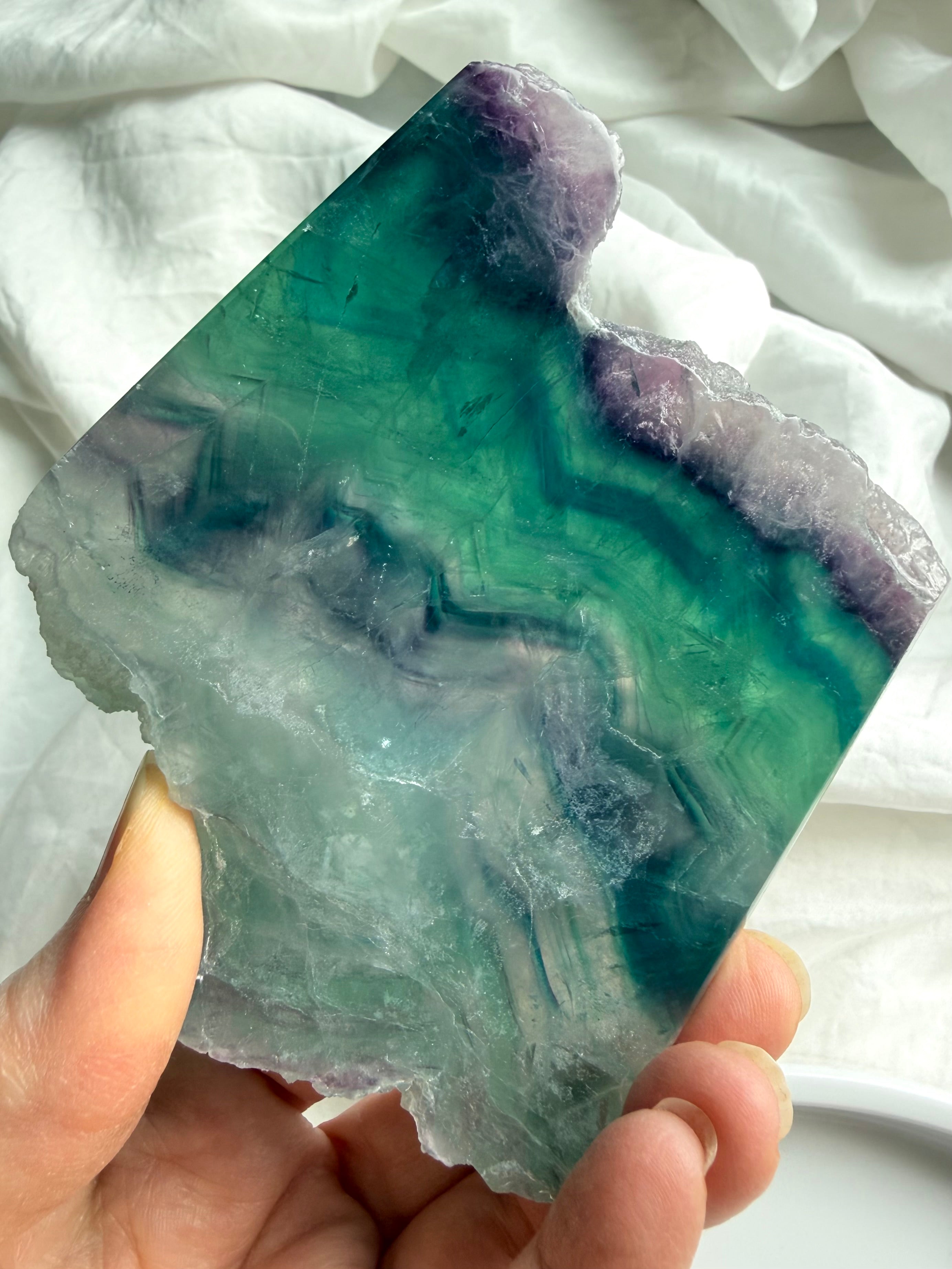 Detail view of one of a kind fluorite slab with raw crystal formation and smooth polished edges