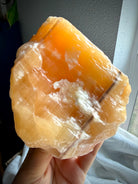 Natural Orange Calcite crystal chunk with glowing translucency, rough formations, and glossy acid-washed finish
