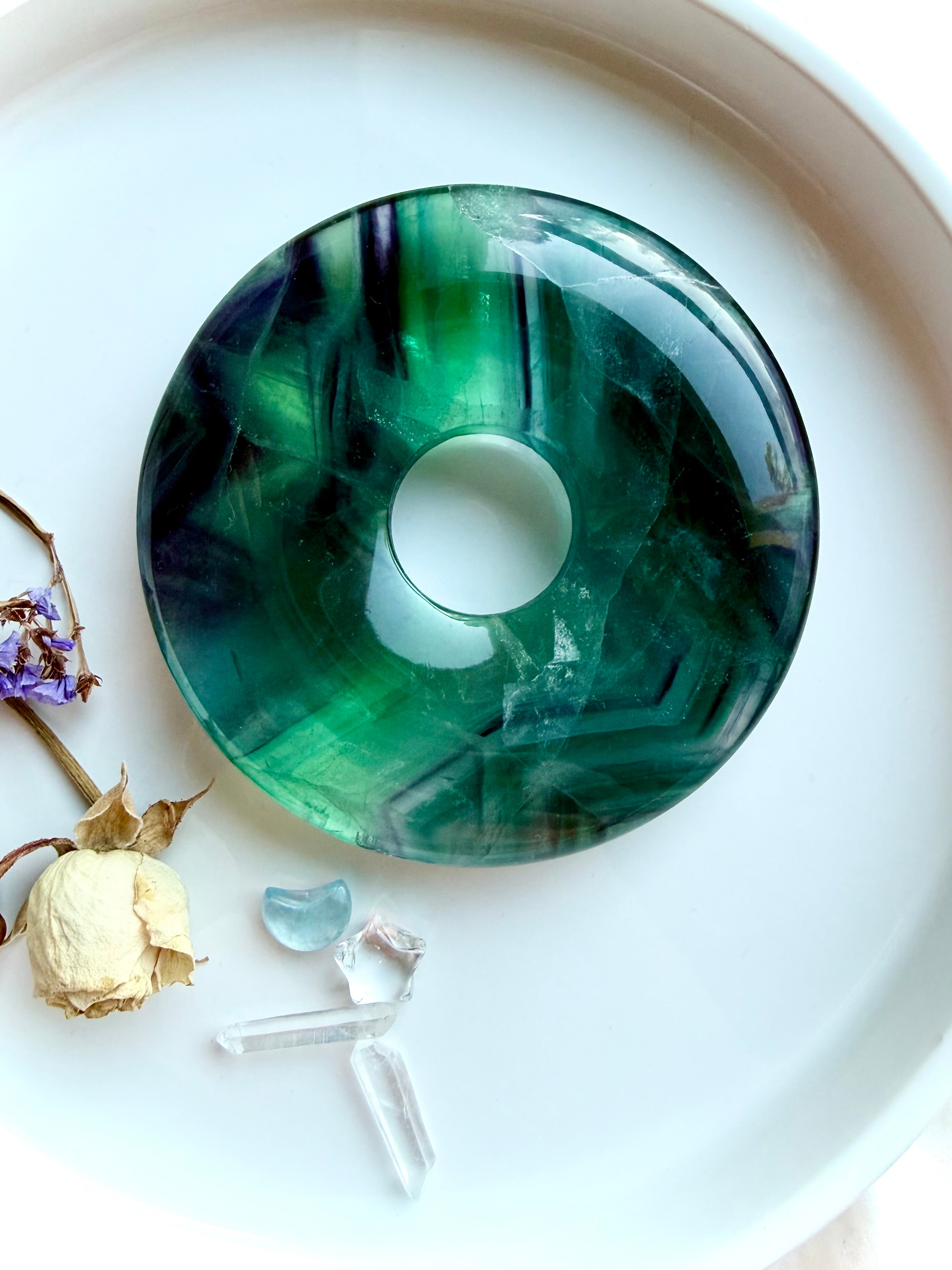 One of a kind rainbow fluorite donut on stand. Crystal peace buckle display piece for balance, clarity, calm energy, and sacred space decor. Includes gold metal stand.