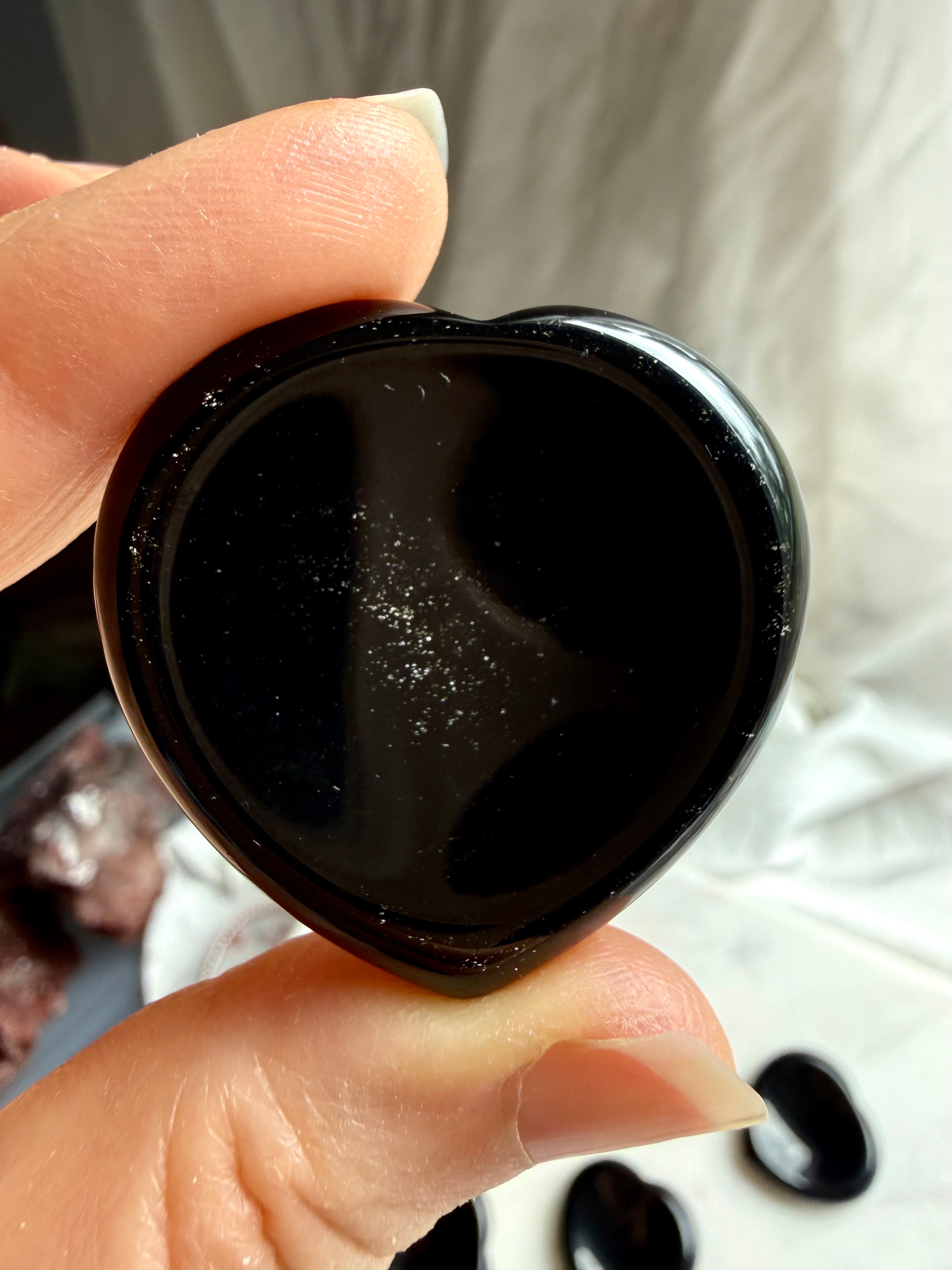 polished sheen obsidian heart worry stone close up showing reflective silver flash and smooth finish
