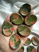 unakite worry stones displayed on hand for scale, for heart chakra healing & emotional balance