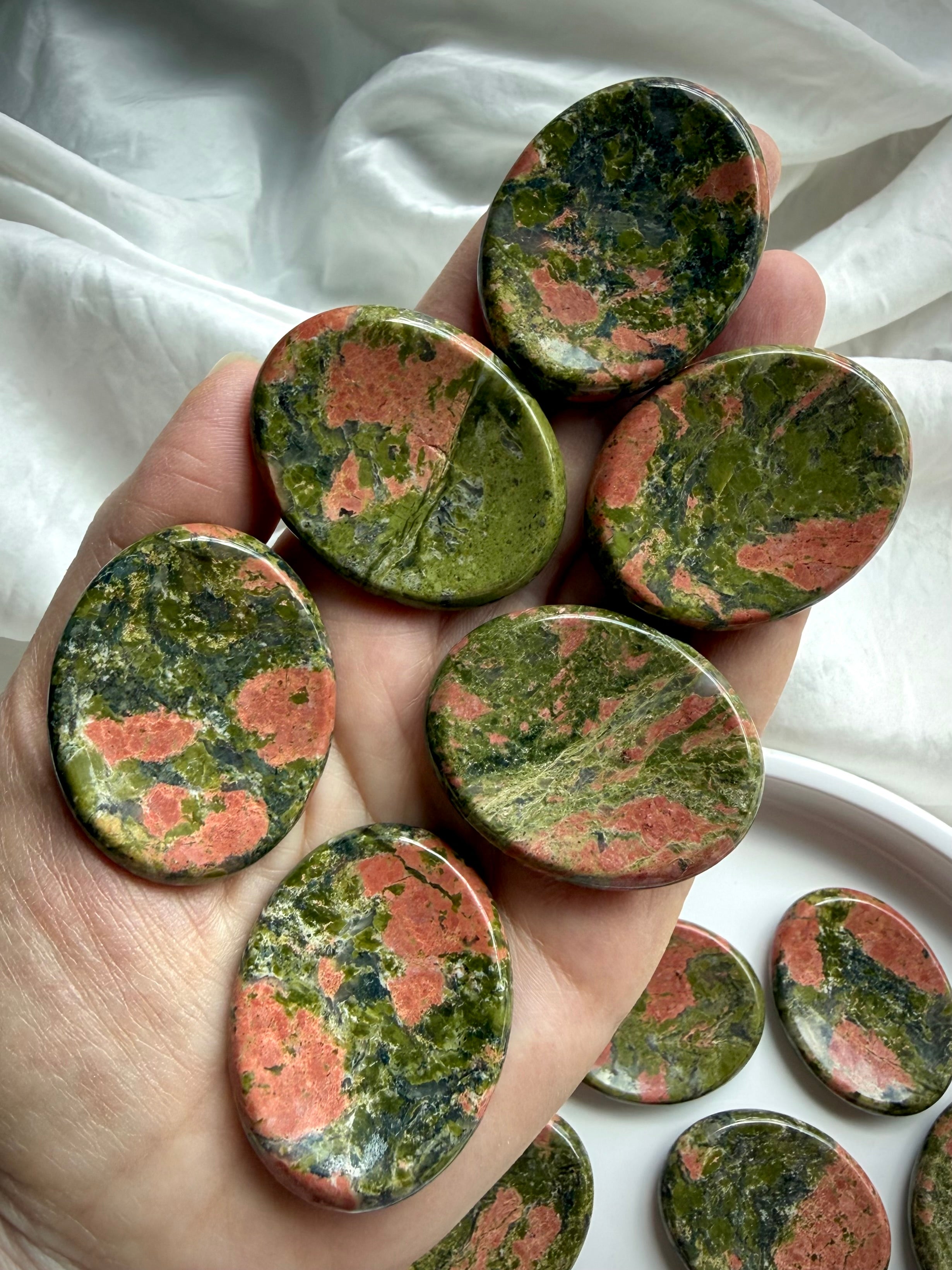 unakite worry stones displayed on hand for scale, for heart chakra healing & emotional balance