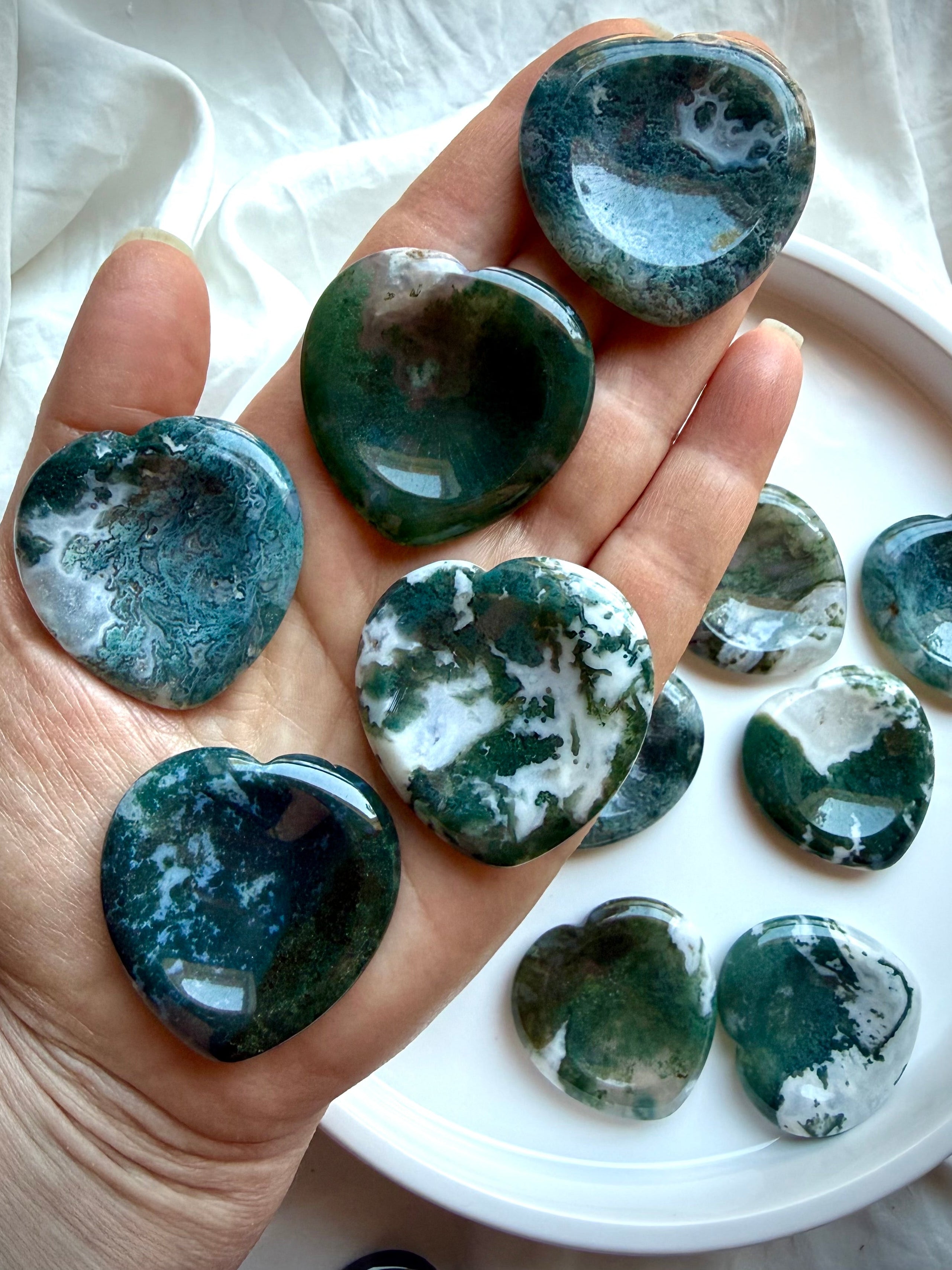 Moss Agate heart worry stone shown on hand with translucent quartz and lush green moss inclusions